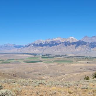 A view of a valley with mountains in the background.