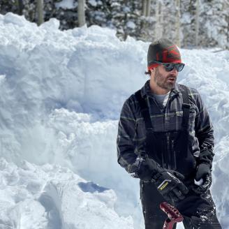 Hydrologist in front of wall of snow.
