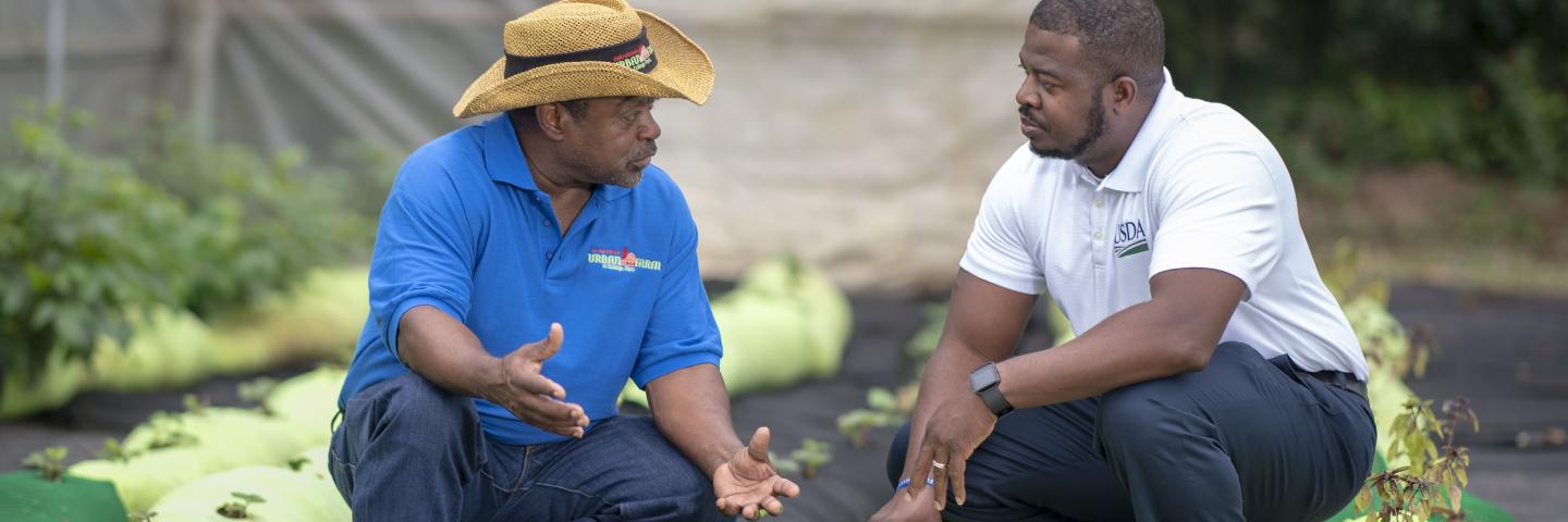 Two African American men talking while working.