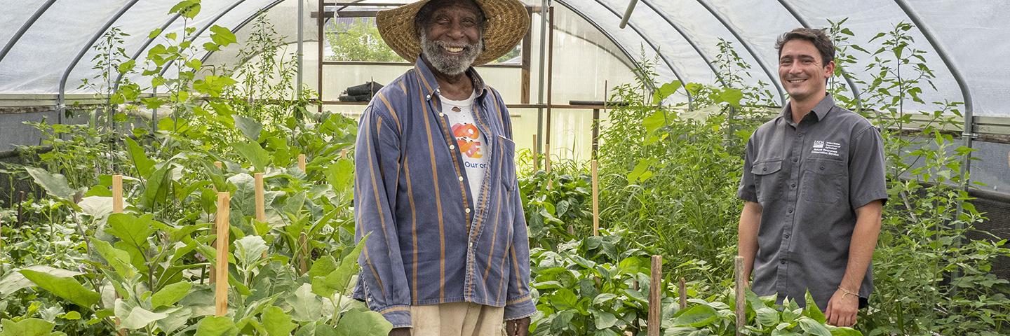 A farmer and an NRCS employee in a seasonal high tunnel