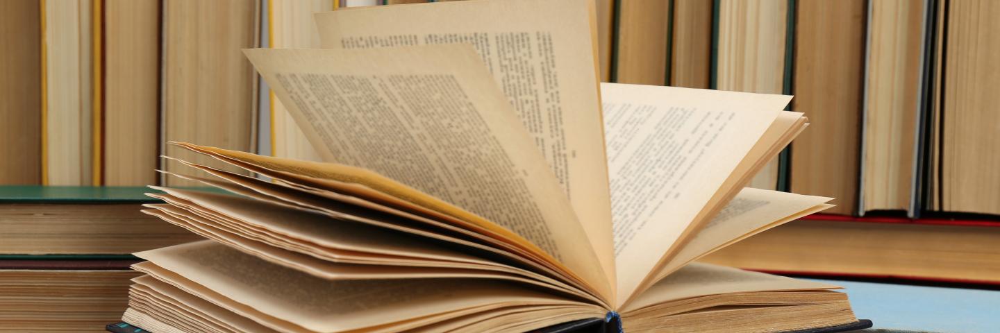 Many hardcover books as background, closeup.