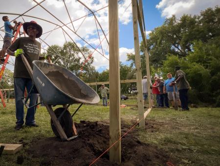 Volunteers build a high tunnel in a food desert neighborhood of Waterloo, Iowa, July 29, 2022