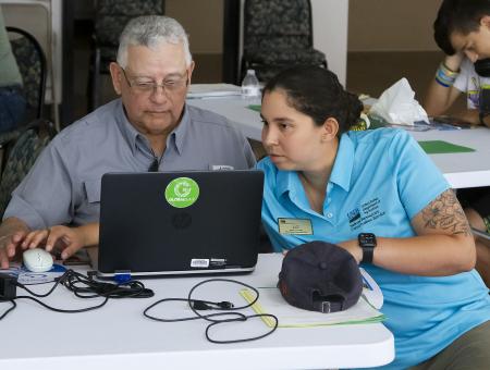 NRCS staff member confers with a partner at an outreach event