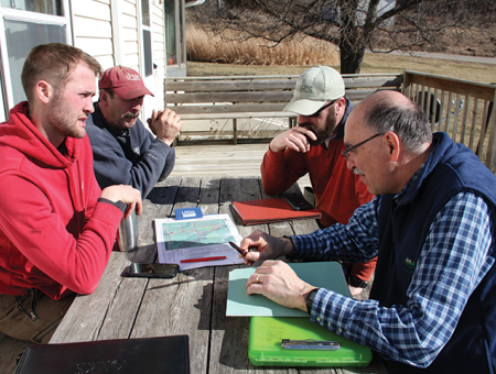 Producer with field staff going over payment schedule.