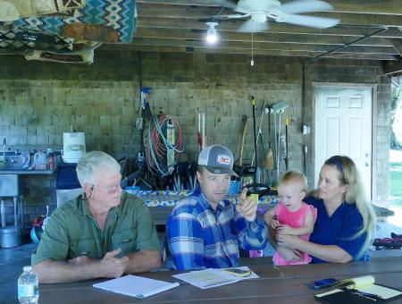 The Foos Family meet with NRCS District Conservationist under a pavillion at their ranch..