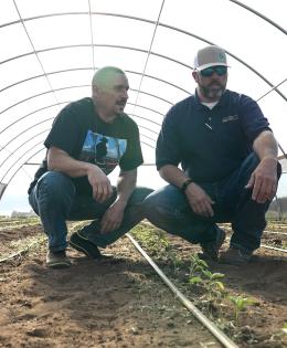 Texas NRCS employee visits with the owner of the Texas Food Ranch inside a high tunnel/